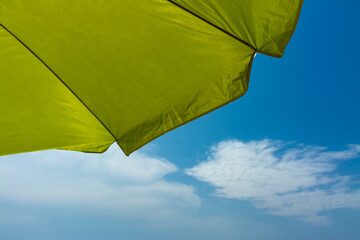 Beach umbrella on the shore with blue background