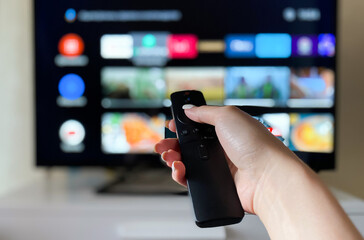 Hand holds remote control from smart TV