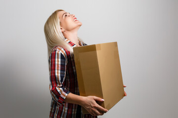 A young beautiful caucasian woman holding a box in her hands.