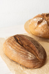 Loaf of homemade bread from wheat and seeds on parchment paper