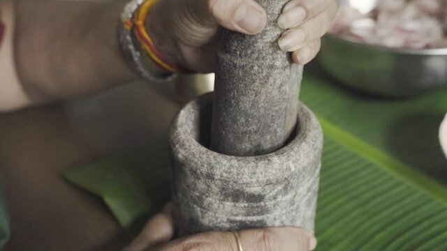 Hand Crushing Ingredients With Mortar And Pestle In Goa, India - close up
