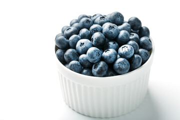 Blueberries in a white Cup on a white background. Isolate, free space