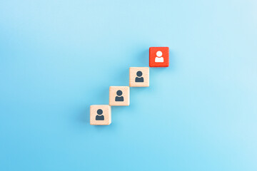 Red wooden cube with person icon stand out from the crowd on blue background, Leadership concept