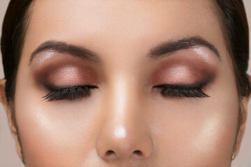 Fototapeta premium close up of a face with professional makeup and the closed eyes, studio