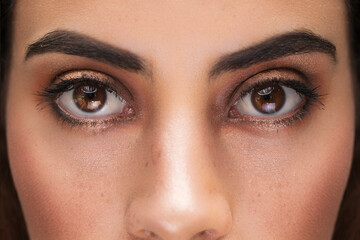 Obraz premium detail of latin young woman face with open eyes, beautiful makeup on the eyelids, studio