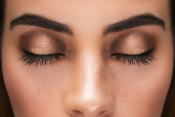 detail of a face with closed eyes, beautiful makeup on the eyelids