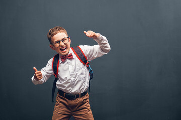 cheerful, mischievous Caucasian schoolboy boy in glasses and a uniform