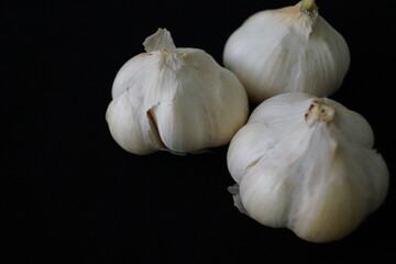 Cabezas de ajos y dientes de ajos sobre fondo negro