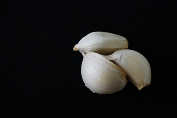 Cabezas de ajos y dientes de ajos sobre fondo negro
