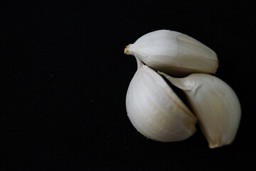 Cabezas de ajos y dientes de ajos sobre fondo negro