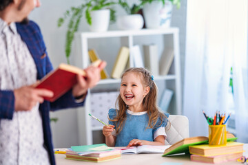 Fototapeta premium ?ute little girl is engaged in lessons with a teacher at home.