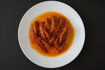 Cangrejos de río en salsa de tomate, con cebolla y pimiento rojo y verde