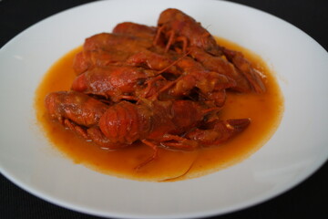 Cangrejos de río en salsa de tomate, con cebolla y pimiento rojo y verde