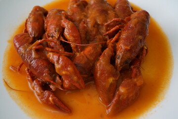 Cangrejos de río en salsa de tomate, con cebolla y pimiento rojo y verde