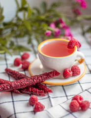 Obraz na płótnie Canvas cup of tea with red raspberry marshmallow sticks