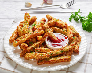 zucchini sticks on a white plate with ketchup