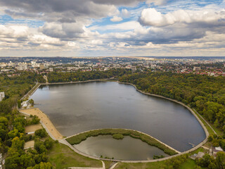 Obraz premium Aerial view of a lake in a park with autumn trees. Kishinev, Moldova. Epic aerial flight over water. Colorful autumn trees in the daytime.