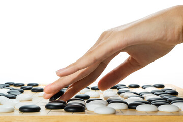 close up of player hand with weiqi stone to make a move in Go game (Weiqi, Baduk, Go ban) - The  Ancient Traditional Asian strategy board game