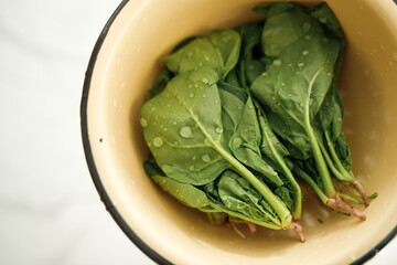 wet spinach leaves in a colander