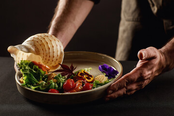 The chef prepares a salad of seafood and vegetables.