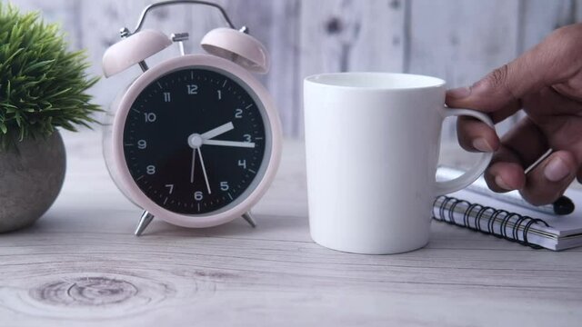 Close up of man hand putting coffee mug on table 