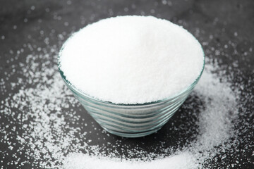 A glass bowl with white sugar	
