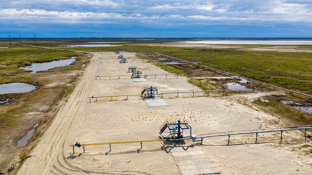 Oil, Gas Industry. Group Wellheads And Valve Armature , Gas Valve, Gas Well Of High Pressure,  Aerial View, Landscape Of The Forest-tundra