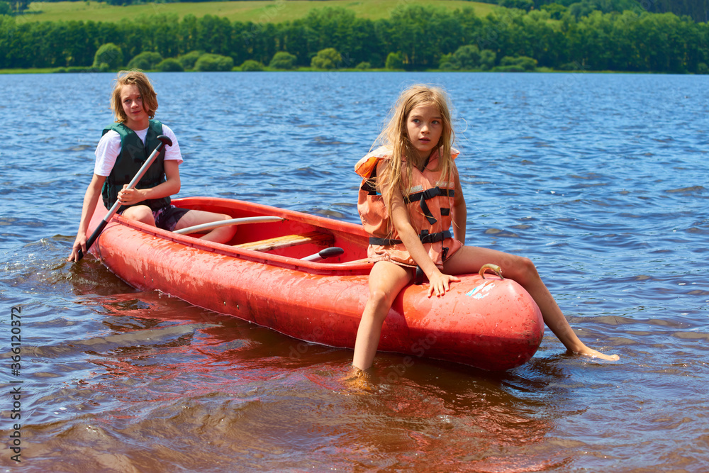 Wall mural children siblings girl and boy (brother and sister) kayaking on vacation