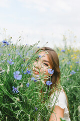The girl in the cornflower-blue field. Beautiful woman and cornflowers in the field. Belarusian.