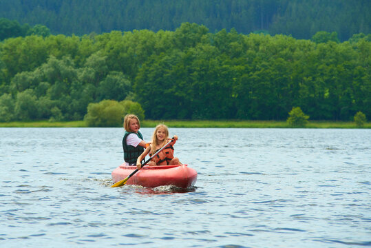 Children siblings girl and boy (brother and sister) kayaking on vacation
