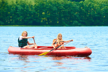 Children siblings girl and boy (brother and sister) kayaking on vacation
