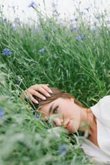 The girl in the cornflower-blue field. Beautiful woman and cornflowers in the field. Belarusian.