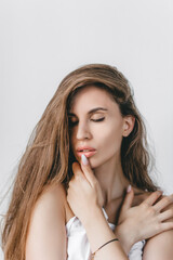 Close-up portrait of a sexy caucasian girl with closed eyes with long brown hair. Healthy hair and beautiful professional makeup. Hair care, skin care concept