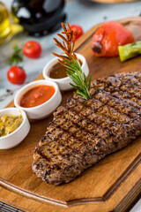 Fresh delicious juicy steak with vegetables on wooden background.