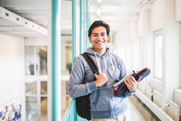 Portrait of confident young male student in corridor of university