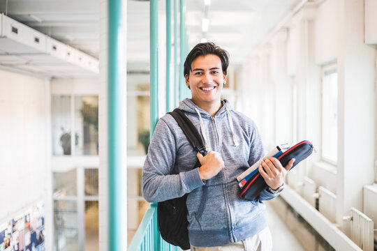 Portrait of confident young male student in corridor of university
