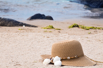 hat and shells on the beach, summer vacation concept