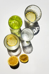 Modern glasses with shadows and lemons. Summer still life scene