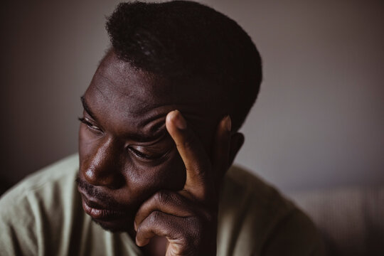 Close-up of sad man holding head in hand while looking away
