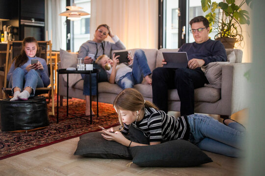 Family is using technologies in living room at modern home