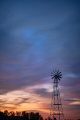 Silhouette of Windmill Against Colorful Cloudy Sky at Sunset in Rural Louisiana