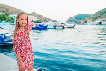 Adorable little girl in port at summer day