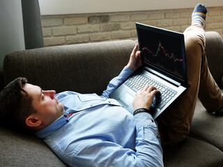 A man at home is analyzing trading on an online exchange.