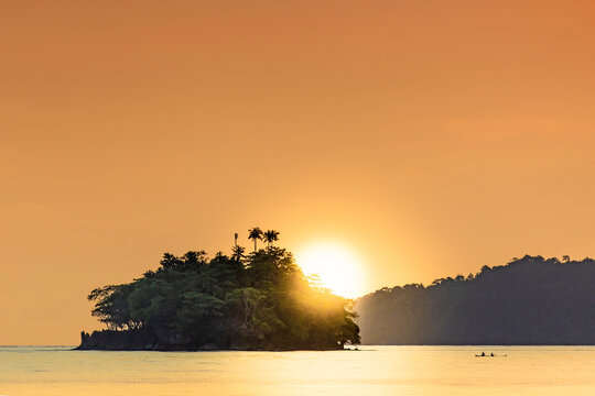 The sun setting behind islets in the Banda archipelago, Banda, Maluku, Spice Islands, Indonesia