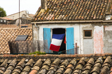 Francja , Prowansja , sierpień 2019 , drzwi z flagą francuską budynku w Aigues-Mortes - obrazy, fototapety, plakaty