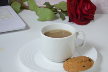 office table with notebook, computer keyboard, mouse, cup of coffee, red rouse. copy space