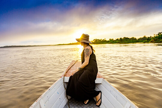 Woman enjoying sunset on the river, Amazon River, Peru