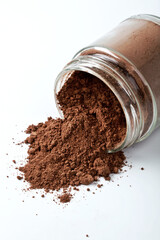 Jar of Cocoa Powder on the White Background Closeup