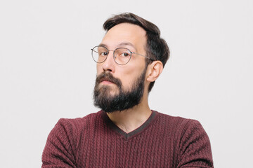 Obraz premium pensive young man in a burgundy sweater in the studio on a white background