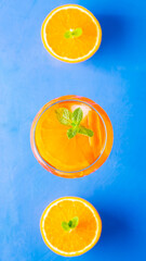 Aperol spritz cocktail on a blue background. Glass of aperol spritz with orange slised. Summer cocktail in glass. Top view. Copy space